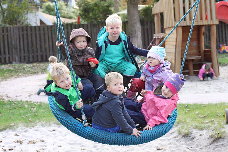 Kinder beim schaukeln in der Kita