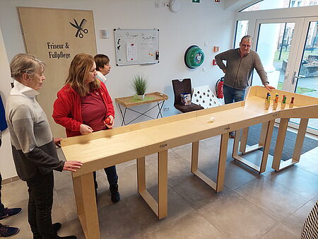 Bewohnerinnen und Pflegerin des DRK-Wohnpark Gutshof testen die neue mobile Kegelbahn aus Holz. Hinten steht Helmut Holthaus, Spender und Erbauer der Kegelbahn.