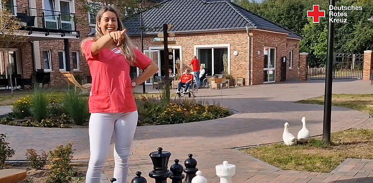 Pflegeazubi spielt Schach mit Senioren