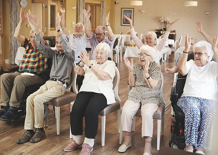 Senioren beim gemeinschaftlichen Fitness im Sitzen