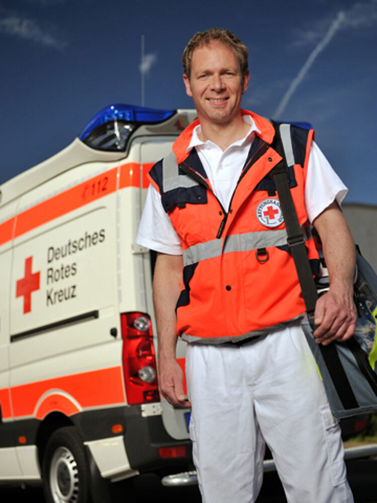 Notfallsanitäter vor einem Rettungswagen